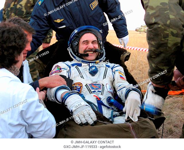 Cosmonaut Pavel V. Vinogradov, Expedition 13 commander, shares a light moment with Russian and American search and recovery teams on the steppe of central...