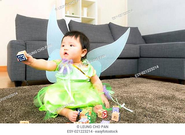 Asian baby girl with halloween party dressing and play toy block