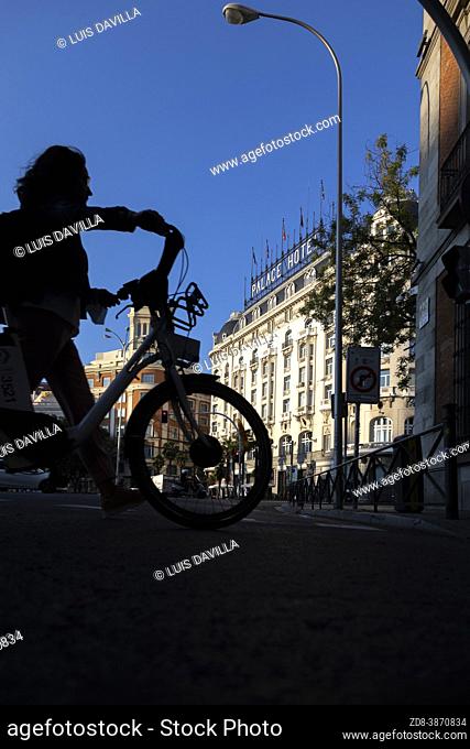 cyclist silhouette in neptuno square with the palace hotel. madrid. spain