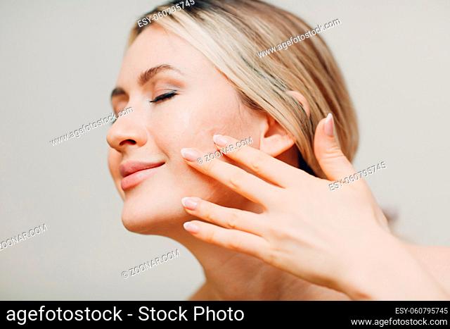 Cosmetic oil royal jelly applying with pipette on face of young woman