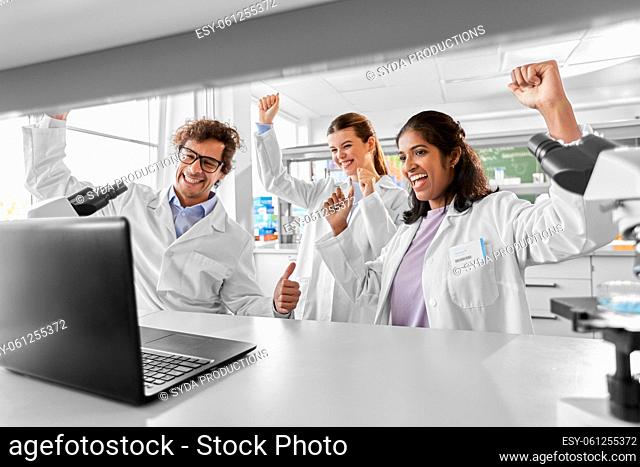happy group of scientists working in laboratory