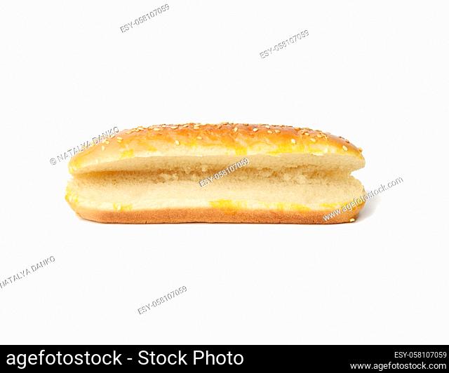 baked oval hot dog bun, baked goods sprinkled with sesame seeds and isolated on white background, bun cut in half