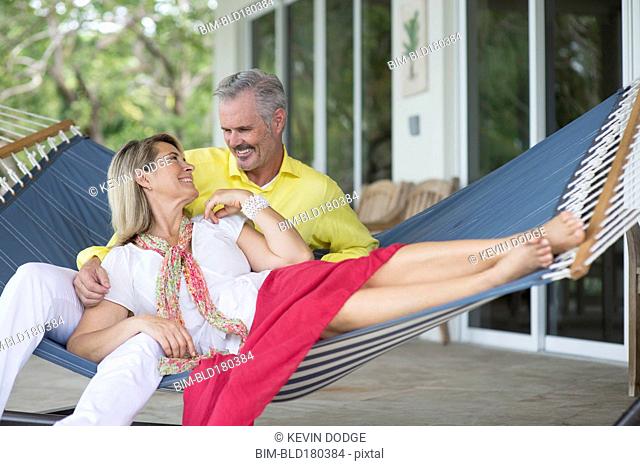 Older Caucasian couple laying in hammock