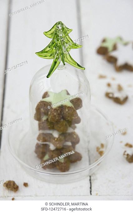 Cinnamon stars with green icing under a glass cloche