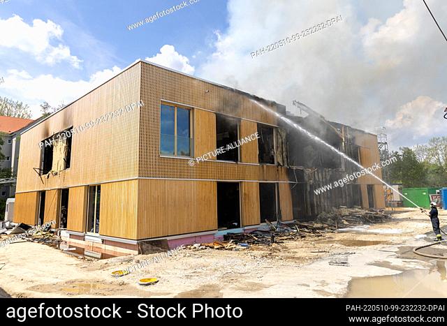 10 May 2022, Bavaria, Nuremberg: Firefighters are still extinguishing the construction site of a new daycare center that was destroyed by the fire