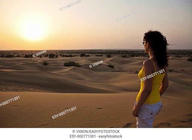 Woman Looking At Sunset khuri dunes in thar desert near jaisalmer in rajasthan state in india