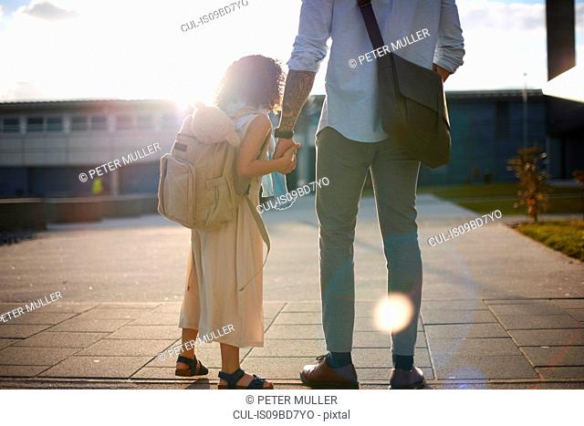 Father holding daughter's hand