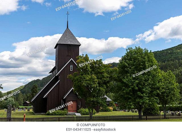brown wooden stave church near Leira in Norway with cemetery