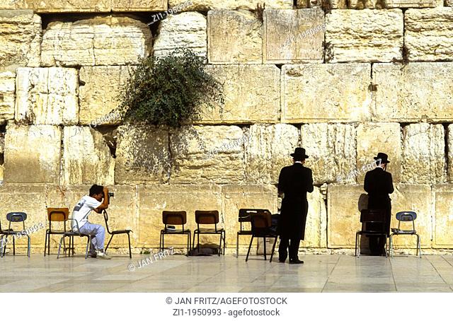 Two praying jews at the Wall at Jerusalem being photographed