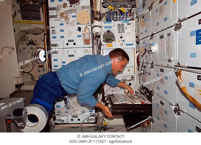 Astronaut Doug Wheelock, STS-120 mission specialist, makes his selection for a meal at the galley on the middeck of Space Shuttle Discovery while docked with...
