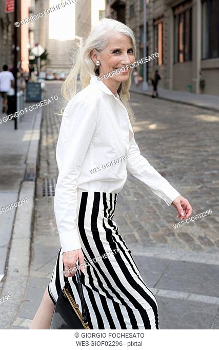 USA, Brooklyn, portrait of smiling mature woman crossing the street