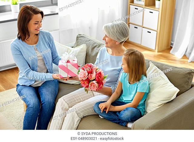 family giving present and flowers to grandmother