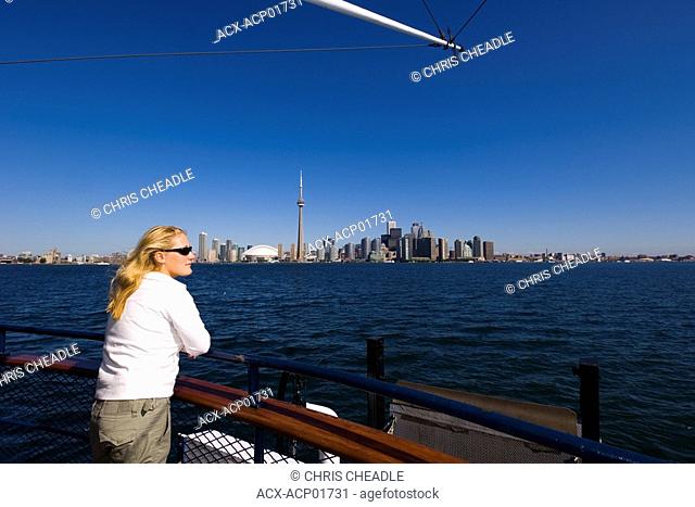 Young woman looks across lake Ontario to downtown from Islands ferry boat, Toronto, Ontario, Canada
