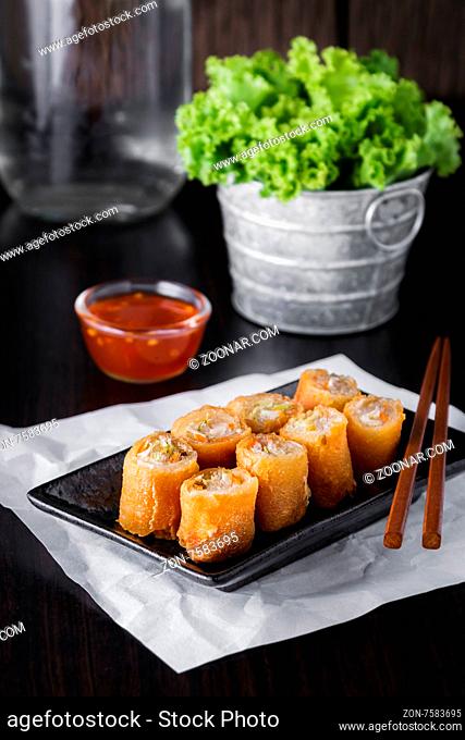 thai spring rolls with sauce on wooden background