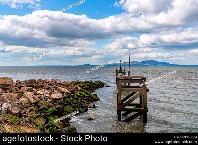 The entrance to the harbour with the coast of Scotland in the background, seen from the West Beach in Silloth, Cumbria, England, UK