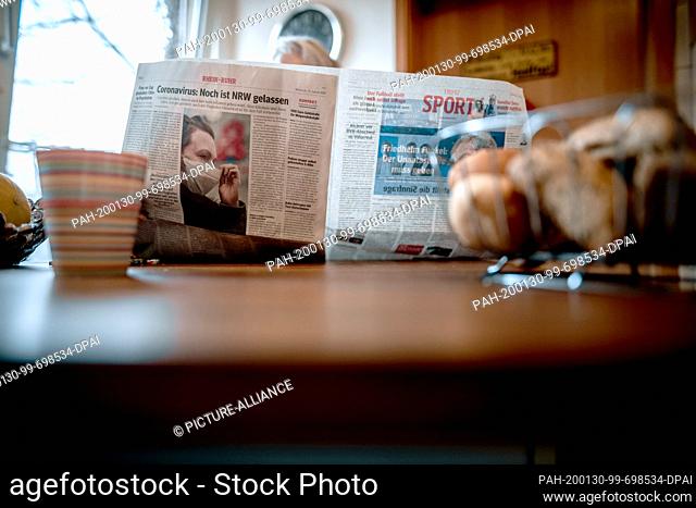 30 January 2020, North Rhine-Westphalia, Oberhausen: ILLUSTRATION - A woman reading a newspaper at the breakfast table. On more than 300 pages