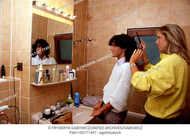 Thomas Anders, Sänger der Band ""Modern Talking"", bekommt von Freundin Nora Balling die Haare gekämmt, Berlin, Deutschland 1985