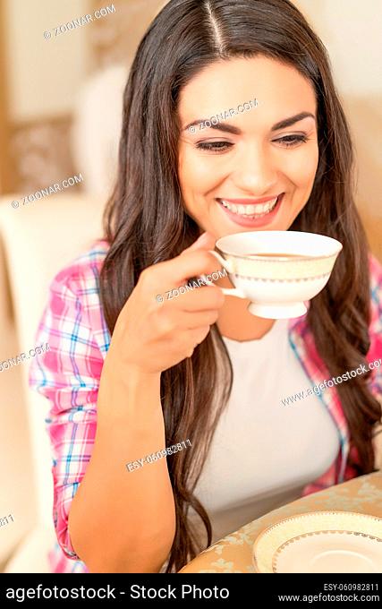 Attractive Woman Thinks And Looks Down While Drinking Tea In The Cafe