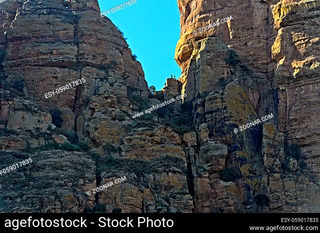 Felswand am Guh Felsturm mit Touristen im Aufstieg zur Felsenkirche Abuna Yemata, Gheralta Massiv, Hawzien, Tigray, Äthiopien / Rock face of the Guh pinnacle...