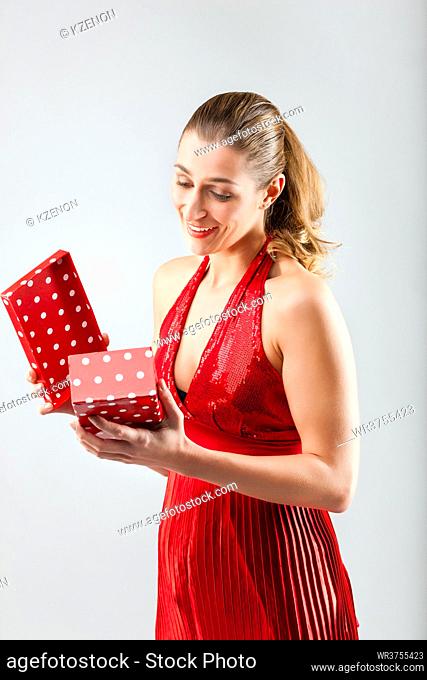 Woman opening the gift and is happy and smiling