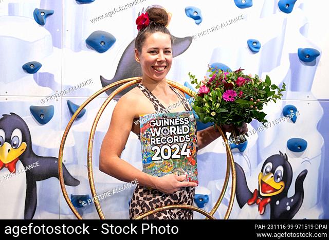 16 November 2023, Saxony, Dresden: Dunja Kuhn poses with a bouquet of flowers after her successful world record attempt to move 84 hula hoops with her body