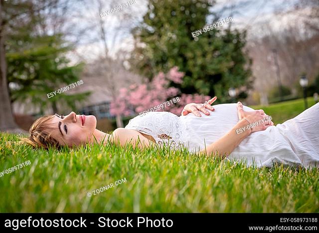 A beautiful expectant mother poses in an outdoor environment