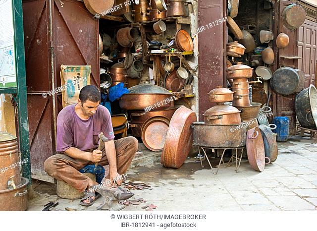 A coppersmith at work outside his shop in the coppersmiths' alley, souk, bazaar, Medina, Fes, Morocco, Africa