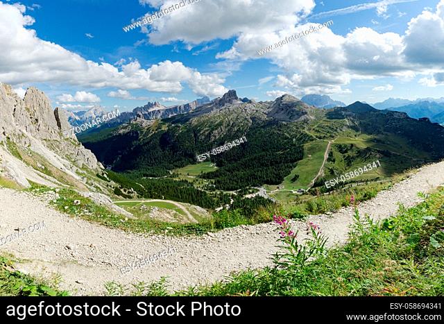 view of wild mountain landscape with rocky peaks and a hiking trail in the foreground in the Italian Dolomites
