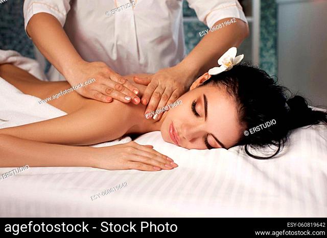 Relaxed beautiful young woman receiving massage in spa salon. Beauty treatment