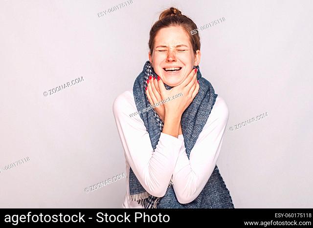 Sick woman touching her neck, have cough, sore throat. Studio shot, gray background