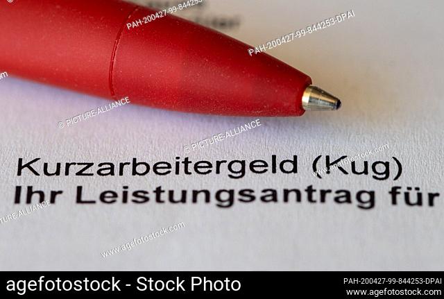 26 April 2020, Saxony, Dresden: A red pencil is placed on an application for short-time work allowance (Kug) from the Federal Employment Agency