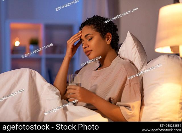 stressed african woman lying in bed at night