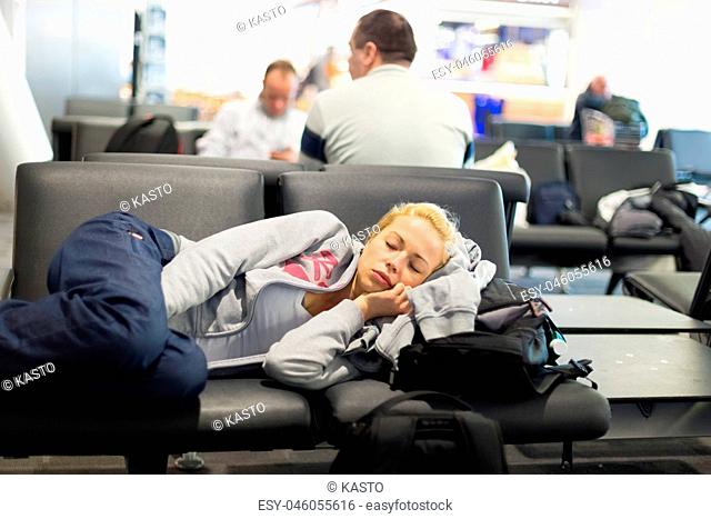 Tired female traveler sleeping on airport