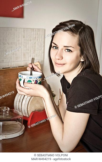 una donna sorridente seduta mentre fa colazione