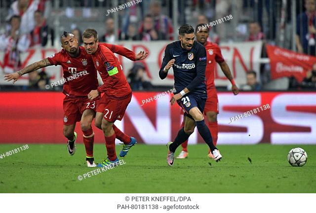 Munich's Arturo Vidal (L-R) and Philipp Lahm in action against Madrid's Yannick Carrasco during the UEFA Champions League semi final second leg soccer match...