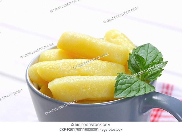 cup of cooked potato cones or gnocchi on white wooden background