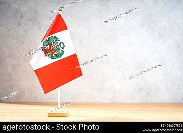 Peru table flag on white textured wall. Copy space for text, designs or drawings