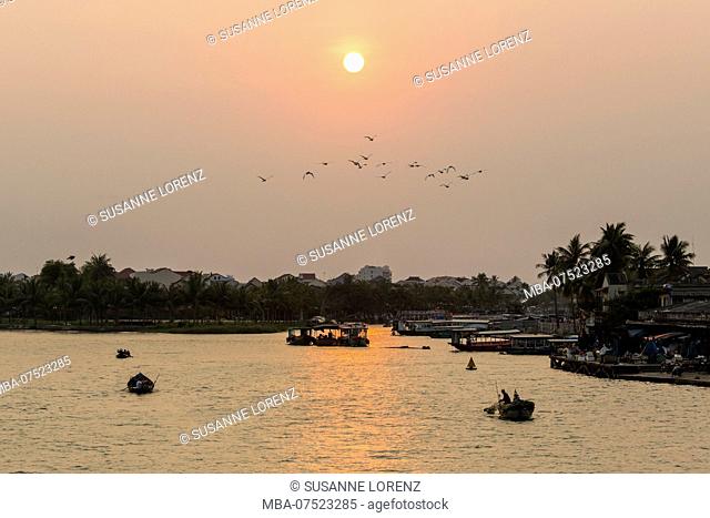 Evening mood, low sun above river in Hoi An, Vietnam, returning fishing boats