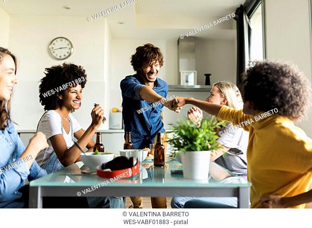 Cheerful friends sitting at dining table