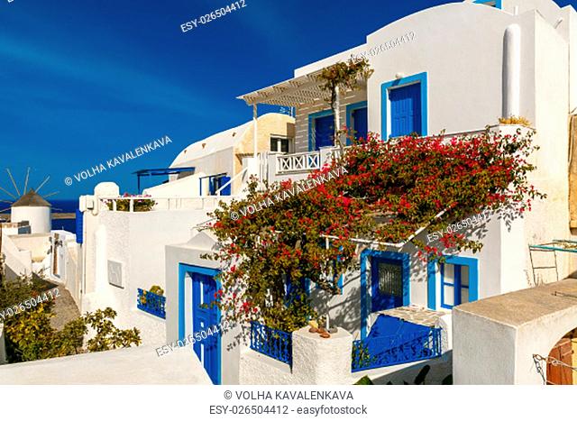 Picturesque view of white and blue houses and windmill in Oia or Ia, island Santorini, Greece