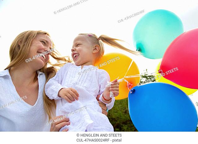 Mother and daughter holding balloons