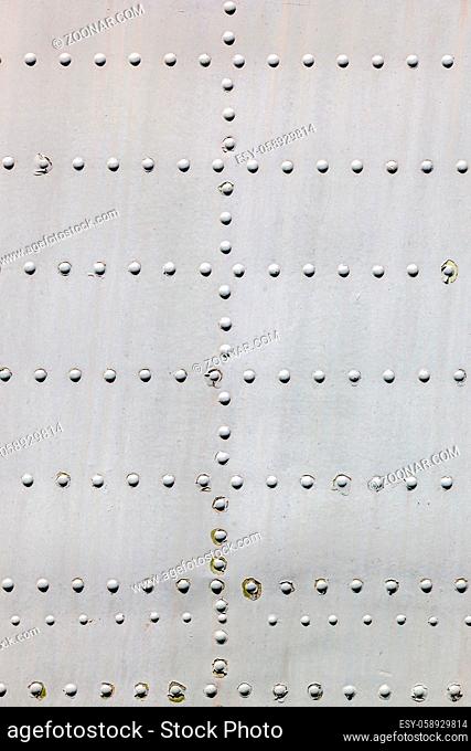 Grey metal surface with rivets as background