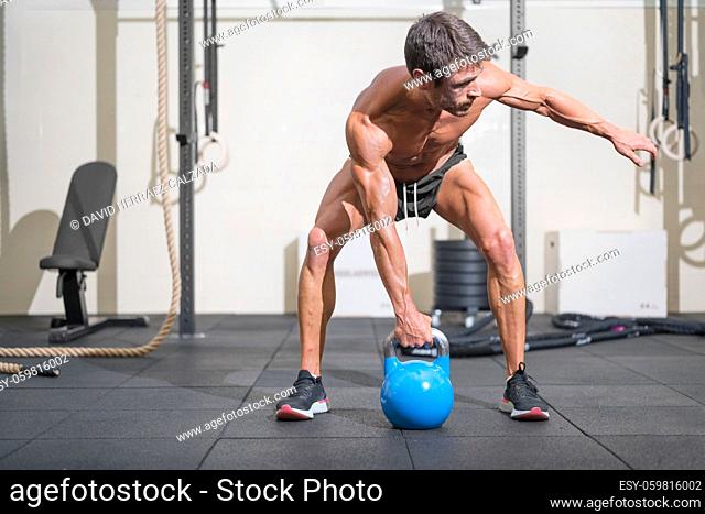 Young muscular man training with kettlebells. High quality photo