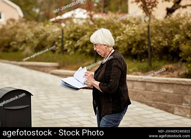 Senior woman standing near mailbox