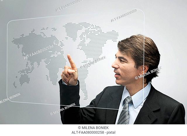 Businessman using advanced touch screen technology to view world map