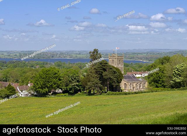 The Church of St Michael the Archangel in the village of Compton Martin at the foot of the Mendip Hills with Chew Valley Lake reservoir in the beyond, Somerset
