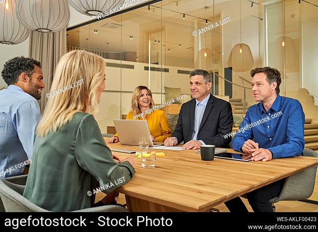 Businessman having discussion with colleagues in meeting at board room
