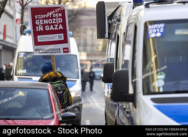 02 December 2023, North Rhine-Westphalia, Duesseldorf: A demonstrator holds up a sign reading ""Stop the genocide in Gaza"" in front of a pro-Palestine rally...