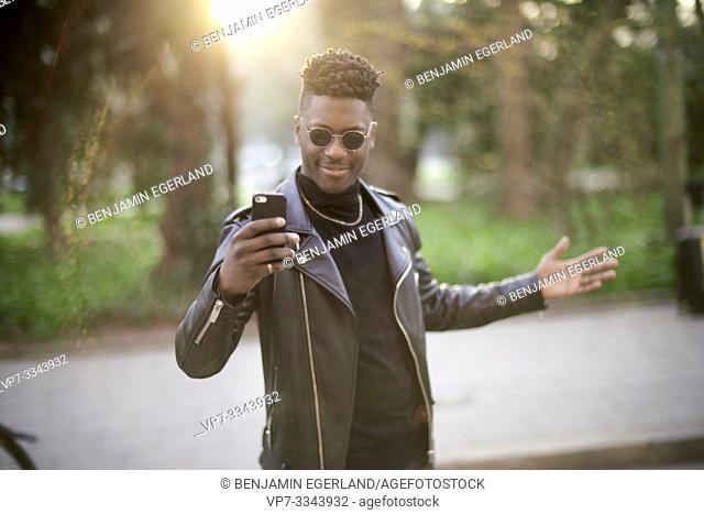 young African man taking selfie with smartphone