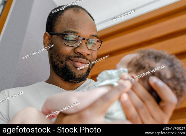 Smiling father carrying baby girl at home